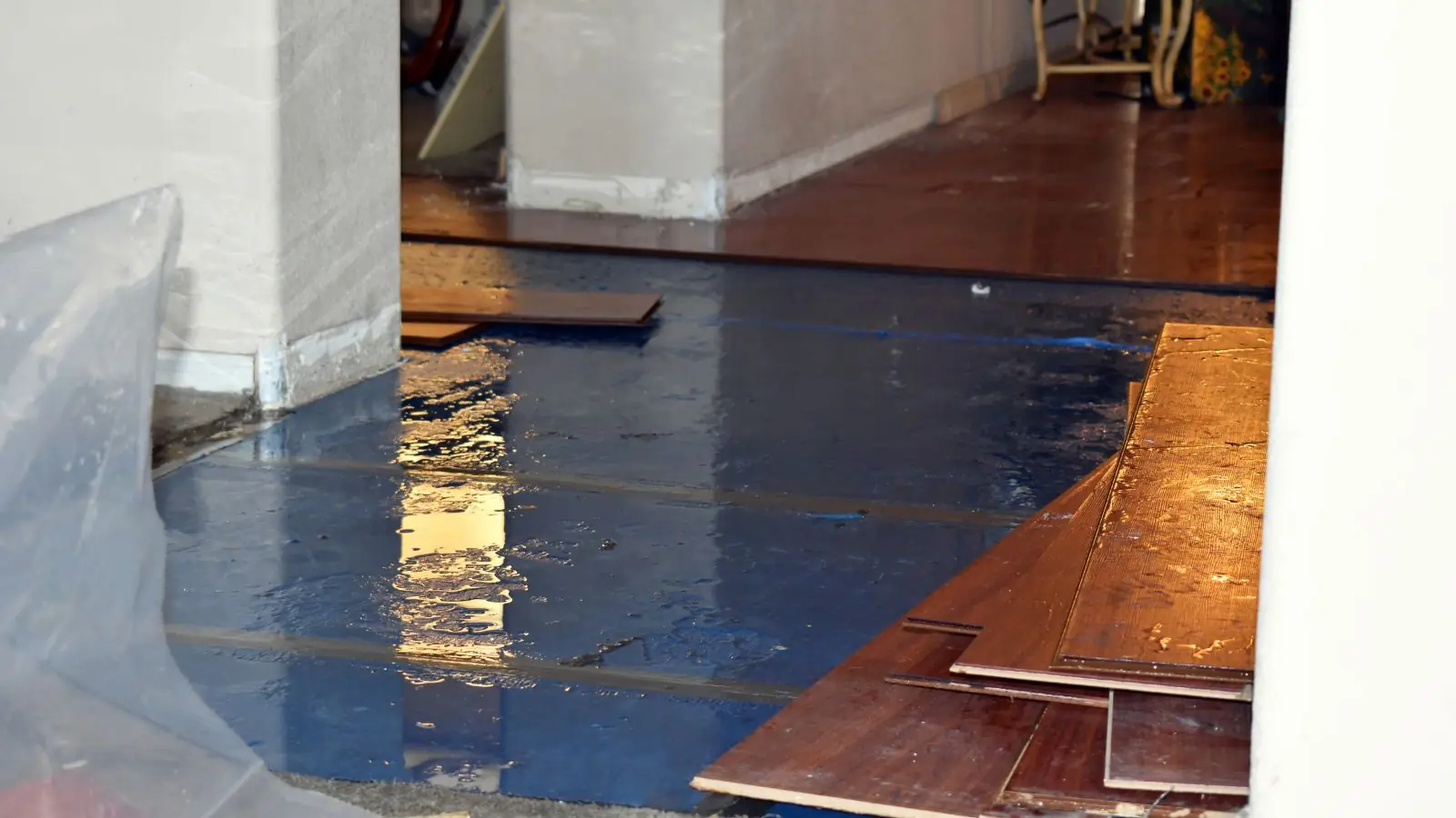 Hardwood boards pulled up from a floor and lying on plastic sheeting