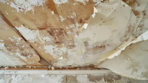 Peeling, stained ceiling paint caused by water damage